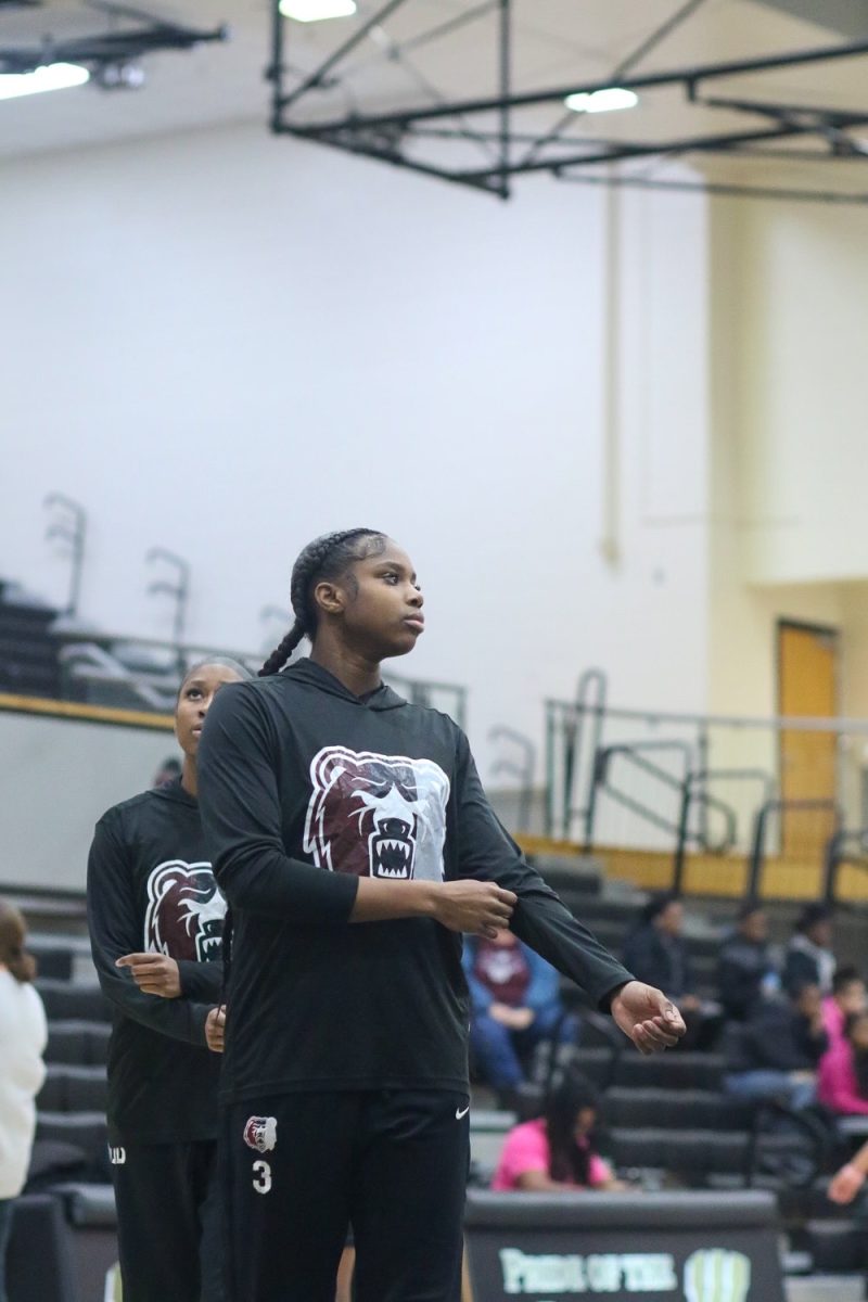 Lola Lampley, Junior, rolls up her sleeves during warmups.