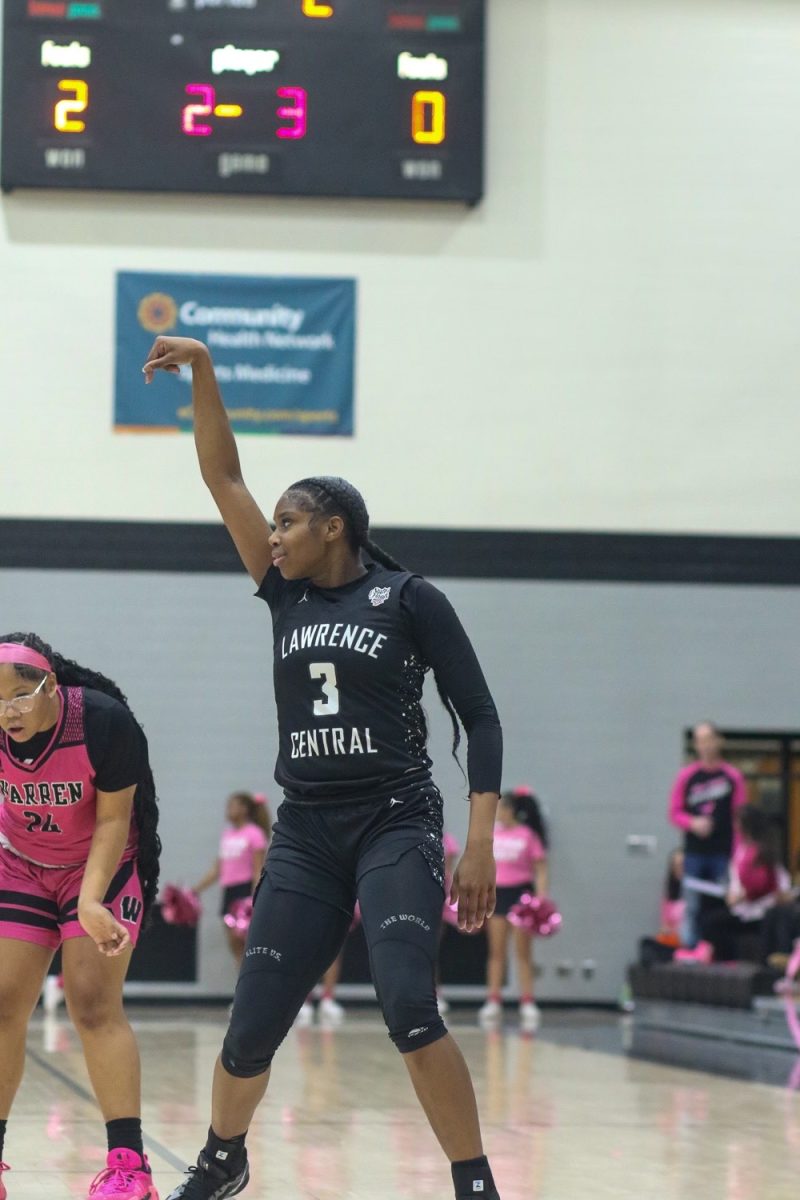 Lola Lampley, Junior, smiles and looks back at the LC bench after hitting a 3 pointer.