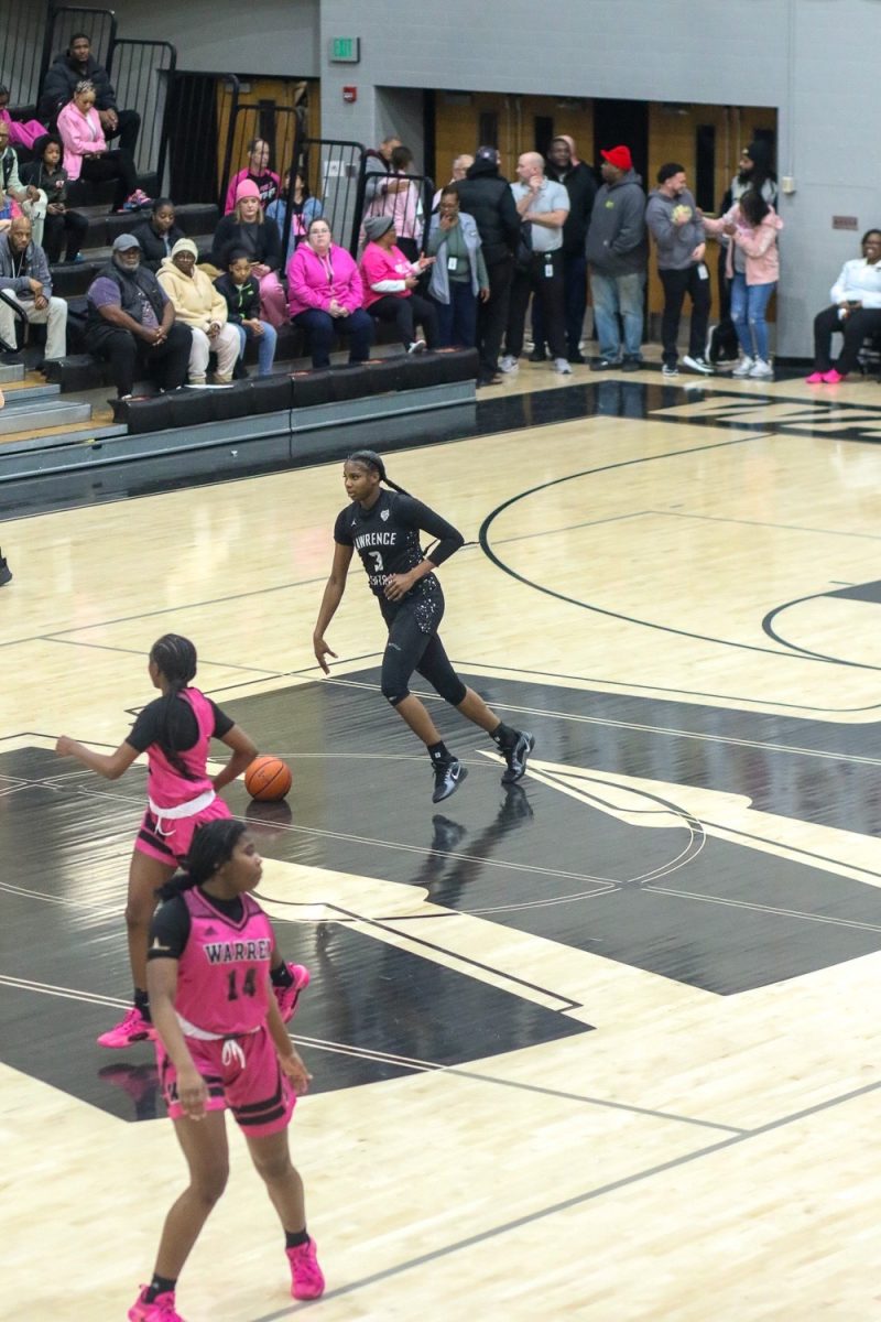 Lola Lampley, Junior, dribbles ball up the court after getting a rebound.